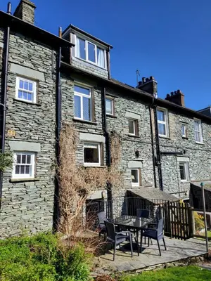 a building with a table and chairs in front of it at Meadow View Chapel Stile in Chapel Stile