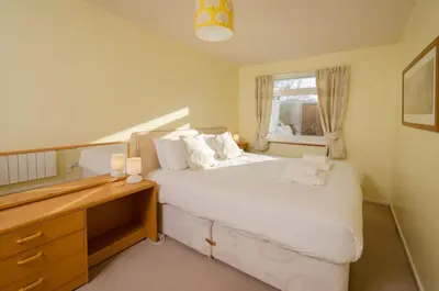 a bedroom with a bed with a dresser and a window at 12 Thrang Brow, Chapel Stile in Chapel Stile