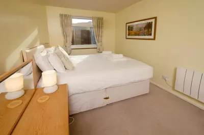 a bedroom with a large white bed and a window at 12 Thrang Brow, Chapel Stile in Chapel Stile