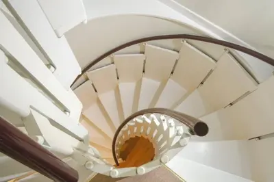 a spiral staircase with a round mirror at 12 Thrang Brow, Chapel Stile in Chapel Stile
