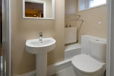 a white bathroom with a toilet and a sink at Beck Steps, Elterwater in Chapel Stile