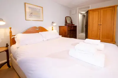 a bedroom with a large white bed with white pillows at Beck Steps, Elterwater in Chapel Stile