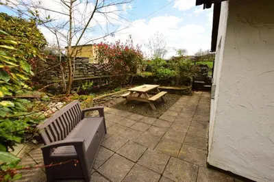 a patio with a bench and a picnic table at Christmas Cottage in Chapel Stile