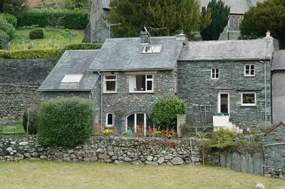 an old stone house with a stone wall at Church Bank in Chapel Stile