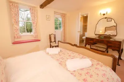 a bedroom with a bed with a vanity and a mirror at End Cottage, Chapel Stile in Chapel Stile