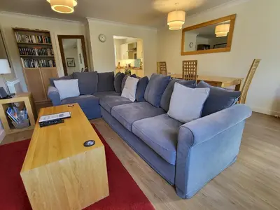 a living room with a blue couch and a coffee table at Lingmell Fell View, Chapel Stile in Chapel Stile