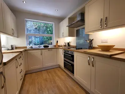 a kitchen with white cabinets and a window at Lingmell Fell View, Chapel Stile in Chapel Stile