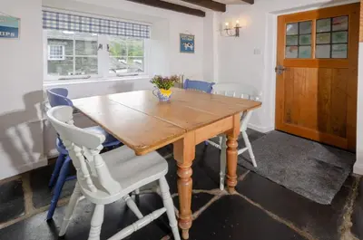 a dining room with a wooden table and chairs at Priest End, Chapel Stile in Chapel Stile