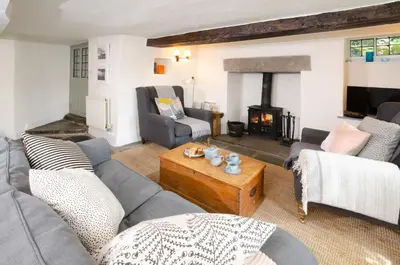 a living room with a couch and a fireplace at Priest End, Chapel Stile in Chapel Stile