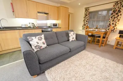 a living room with a couch and a kitchen at Rosegate Cottage, Elterwater in Elterwater