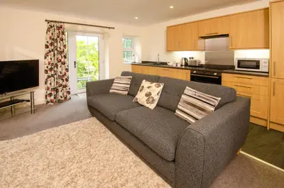 a living room with a couch and a kitchen at Rosegate Cottage, Elterwater in Elterwater