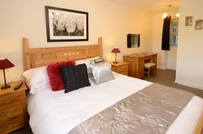 a bedroom with a large bed with pillows on it at Rosegate Cottage, Elterwater in Elterwater