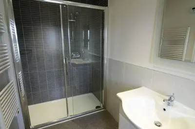a bathroom with a glass shower and a sink at Rosegate Cottage, Elterwater in Elterwater