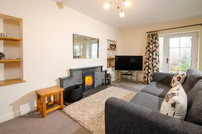 a living room with a couch and a fireplace at Rosegate Cottage, Elterwater in Elterwater