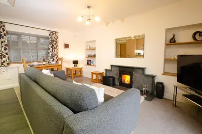 a living room with two couches and a fireplace at Rosegate Cottage, Elterwater in Elterwater