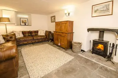 a living room with a couch and a fireplace at Speddy Cottage, Chapel Stile in Chapel Stile