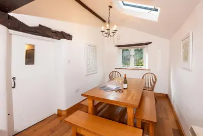 a dining room with a wooden table and chairs at Stickle Cottage, Great Langdale in Grasmere