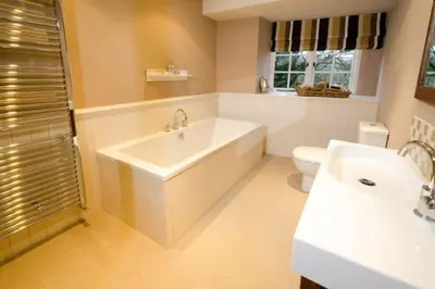 a bathroom with a tub and a toilet and a sink at The Eltermere Old Barn, Elterwater in Elterwater