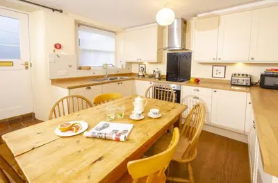 a large kitchen with a wooden table and chairs at The Old Post Office, Chapel Stile in Chapel Stile