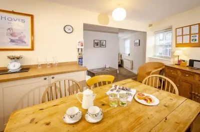 a kitchen and dining room with a wooden table at The Old Post Office, Chapel Stile in Chapel Stile