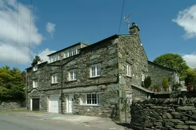 an old stone house on the side of a road at The Stables, Elterwater in Elterwater