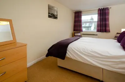 a bedroom with a bed and a dresser and a window at Underthrang, Chapel Stile in Chapel Stile