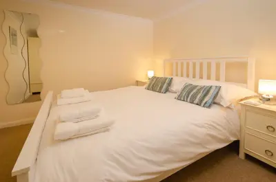 a bedroom with a white bed with towels on it at Underthrang, Chapel Stile in Chapel Stile