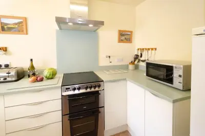 a kitchen with a stove and a microwave at Langstrath, Chapel Stile in Chapel Stile