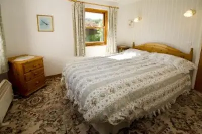 a bedroom with a bed and a dresser and a window at Langstrath, Chapel Stile in Chapel Stile