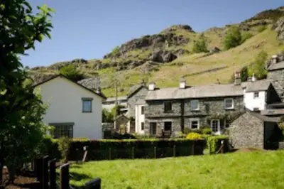 a group of houses with a hill in the background at Langstrath, Chapel Stile in Chapel Stile