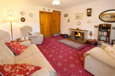 a living room with a couch and a fireplace at Langstrath, Chapel Stile in Chapel Stile