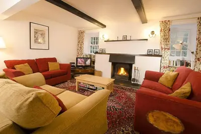 a living room with two couches and a fireplace at Woodland Crag Cottage, Grasmere in Grasmere
