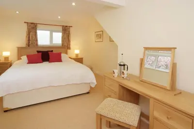 a bedroom with a large bed and a desk with a desk at Lang Parrock, Little Langdale in Little Langdale