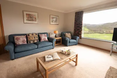 a living room with two blue couches and a coffee table at Lang Parrock, Little Langdale in Little Langdale