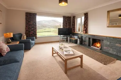 a living room with a couch and a fireplace at Lang Parrock, Little Langdale in Little Langdale