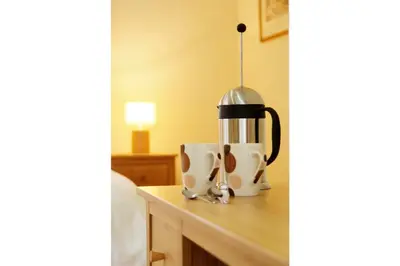 a coffee maker sitting on a table next to a cup at Lang Parrock, Little Langdale in Little Langdale
