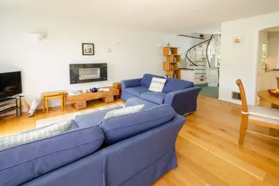a living room with a blue couch and a table at Jadians Nook, 16 Thrang Brow in Chapel Stile