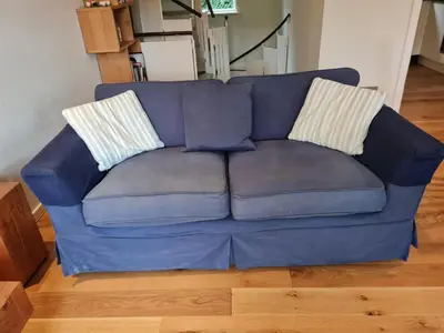 a blue couch with two pillows on top of it at Jadians Nook, 16 Thrang Brow in Chapel Stile