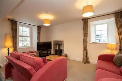 a living room with red furniture and a tv at Victory Cottage - Victory Cottage, Cosy village retreat in Chapel Stile