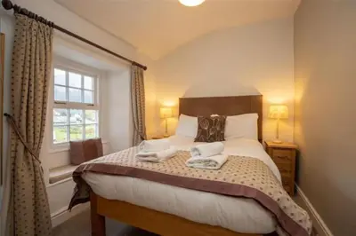 a bedroom with a large bed with two towels on it at Victory Cottage - Victory Cottage, Cosy village retreat in Chapel Stile