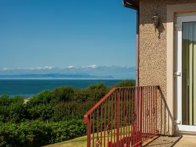 a balcony of a house with a view of the ocean at Cairn-O-Mhor in Lendalfoot
