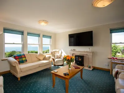 a living room with a couch and a fireplace at Cairn-O-Mhor in Lendalfoot