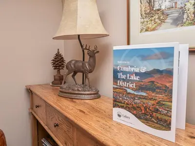 a lamp on a table next to a book at Plumblands in Ambleside
