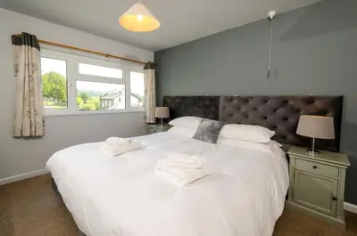 a bedroom with a large white bed with towels on it at Langdale Hideaway in Chapel Stile