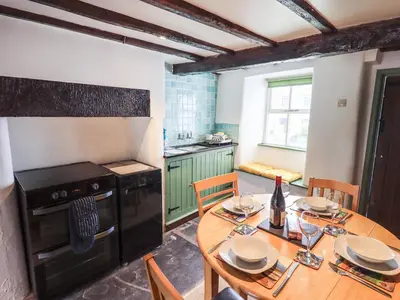 a kitchen with a wooden table and a kitchen with a stove at Blease Garth in Threlkeld