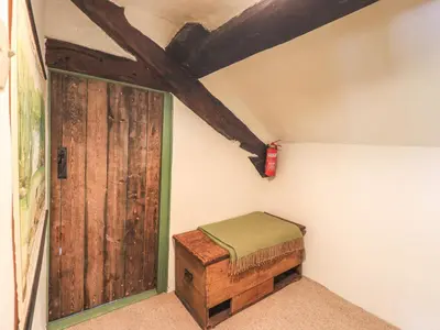 a room with a wooden door and a small stool at Blease Garth in Threlkeld