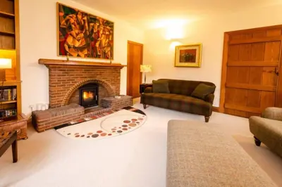a living room with a fireplace and a couch at Heron Place, Great Langdale in Ambleside