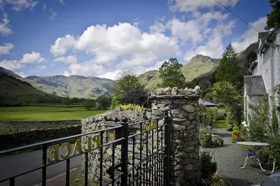a gate to a house with mountains in the background at Heron Place, Great Langdale in Ambleside