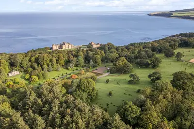 an aerial view of a castle on a hill next to the water at Ardlochan Lodge - Culzean Castle in Maybole