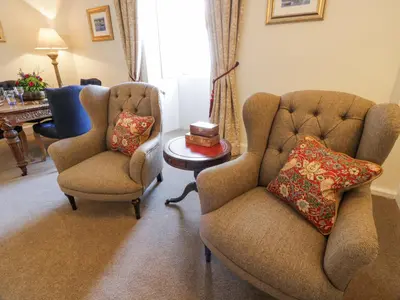 two chairs and a table in a living room at Brewhouse Flat - Culzean Castle in Maybole